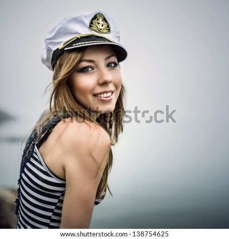 Adorable woman wearing sea Captain\'s cap and sexy sailor T-shirt