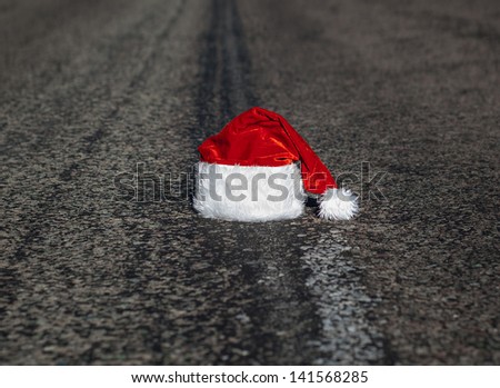 end of christmas holidays - a lost or abandoned red santa hat lies on road