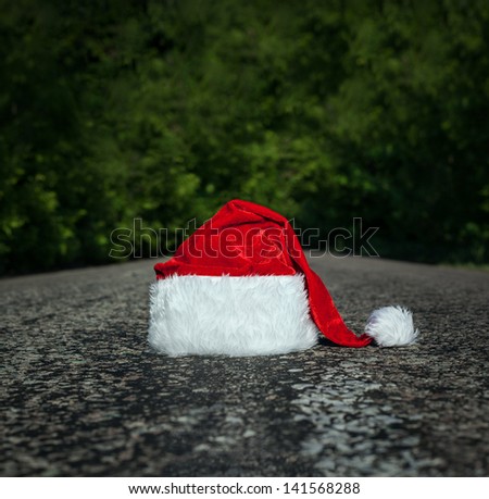 end of christmas holidays - a lost or abandoned santa hat lies on road