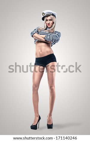 Young Beautiful Adorable Woman in sea peak-cap and stripped vest. Girl - Captain\'s  in sexy sailor T-shirt. Studio shot.