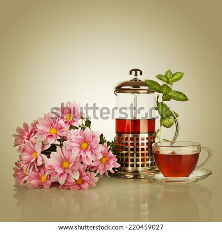 Cup of tea, teapot with mint leaf and beautiful flower