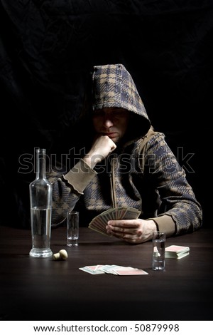 Young man with hood, drinking alcohol and gambling