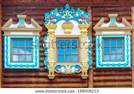 wall of wooden traditional russian house with windows and carved frames and pattern