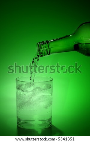 a green isolated bottle pouring wine to the glass on the green background