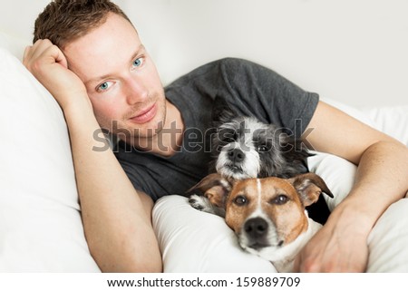 dog owner in bed with two cute dogs