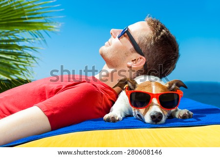 jack russell dog  and owner sunbathing a having a siesta under a palm tree , on summer vacation holidays at the beach