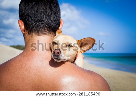 dog and owner sitting close together at the beach on summer vacation holidays, embracing a hug