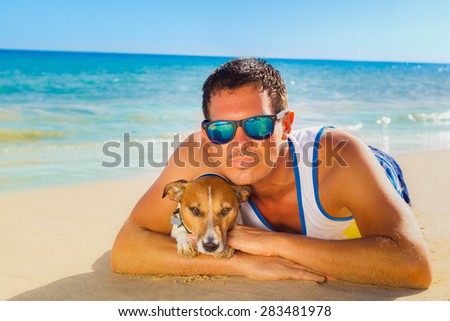 jack russell dog with owner lying at the beach on summer vacation holidays, together and very close