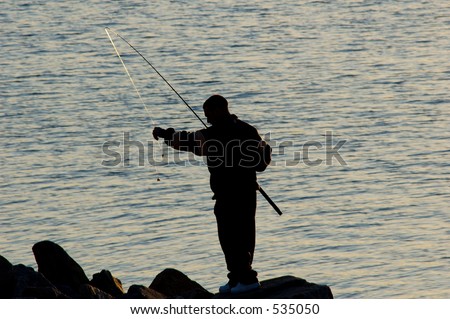 Silhouette of a man casting a line fishing in the evening