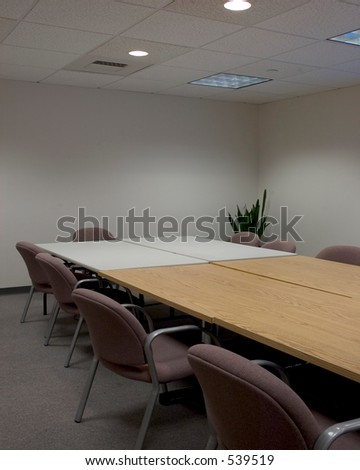 Vertical shot of two conference tables together with chairs around them
