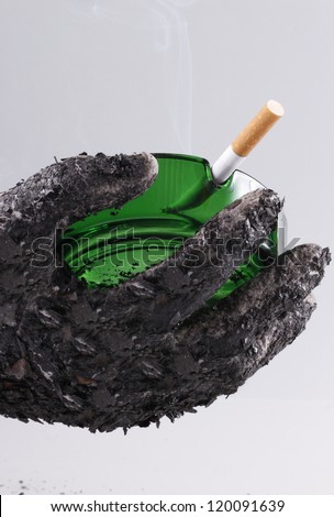 Ashed hand holding green ashtray with a fired cigarette which shows that smoking is harmful/Let\'s smoke!