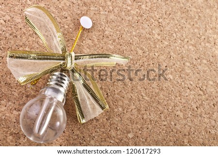 Idea lamp with festive bow on a empty cork-board/Cork-board with idea lamp