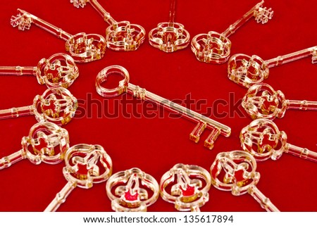 Golden skeleton keys made of plexiglas on a red background/Keys on a red