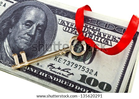 Golden skeleton key on a red cord with a bow on a dollars/Key with a dollars