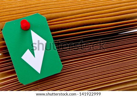 Paper sheets of an old book with a green check mark label and red thumbtack. Image with a copy space for text/Green check mark label