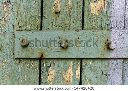 Old green wood door with metal plate and bolts(screws).