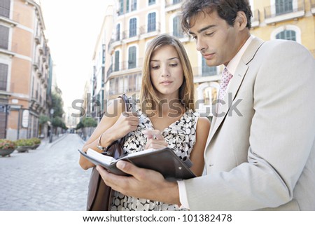 Two business people having a meeting in the city, outdoors.