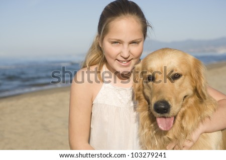 Portrait of girl and god on the beach, smiling at camera.