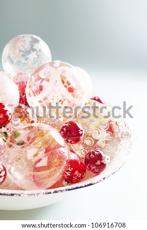 Mountain of quality glass Christmas balls on a plain blue background.