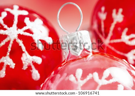 Close up view of red and pink Christmas balls ornaments with a traditional snow flake drawn on them.