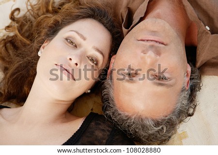 Close up of a mature couple laying down on carpet at home.
