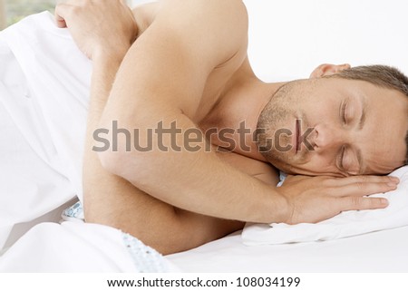 Close up view of a young attractive man sleeping in bed.