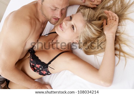 Close up of a sexy couple kissing and playing in bed.