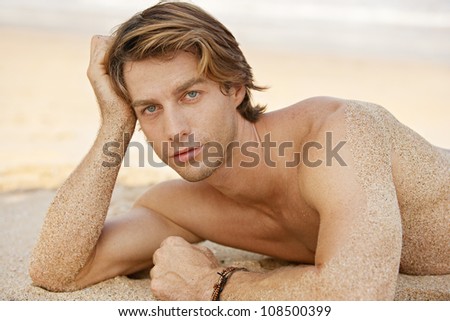 Portrait of an attractive young man sunbathing on the beach.