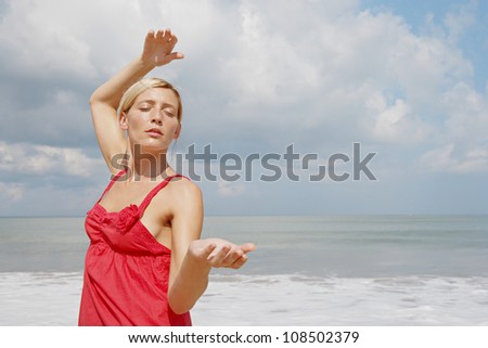 Young attractive woman practicing martial arts on a beach.
