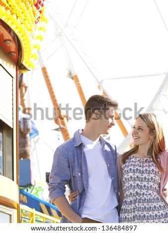 Portrait of an attractive young couple having a fun together in an attractions park during a sunny day, smiling.