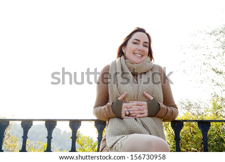 Portrait of an attractive hispanic middle aged mature woman in a home garden, relaxing by a balcony with countryside views, joyful and smiling at camera with space, outdoors.