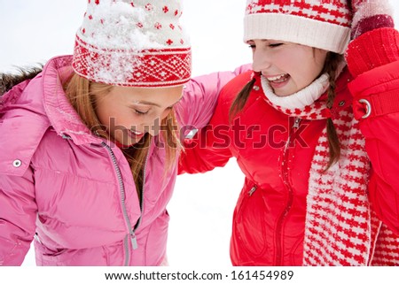 Close up portrait view of two joyful young women friends having fun and laughing while in a skiing holiday in a white snow  landspace lake with big joy expressions and excitement, outdoors.