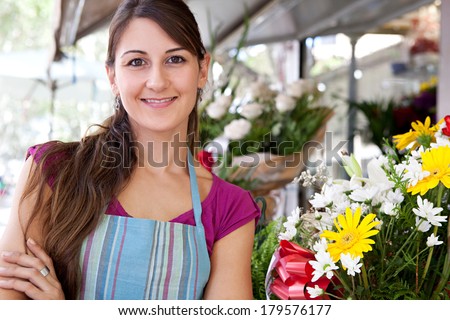 Portrait of a business woman florist working at her flower market shop and feeling proud standing with her arms crossed in front of her small business, outdoors. Business person.