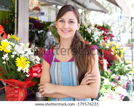 Portrait of a business woman florist working at her flower market shop and feeling proud standing with her arms crossed in front of her small business, outdoors. Business person.