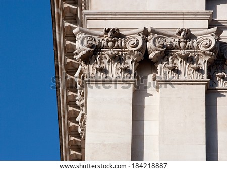 Close up detail view of an old stone building in the city of London with multiple intricate classic architecture design features including columns. Extensive building detail during a sunny day.