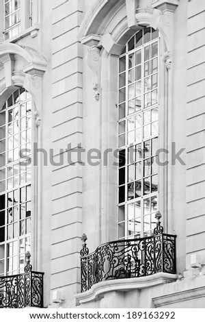 Close up still life detail view of an old stone building with intricate features detail in the city of London with large windows and reflective glass. Classic luxurious architecture background.