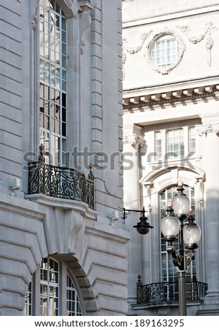 Still life detail view of old stone buildings with intricate features and decorative detail in the city of London with large windows and reflective glass. Classic luxurious architecture background.