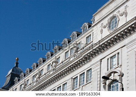 Close up still life detail view of an old stone building with intricate decorative detail in the city of London standing on a bright blue sky. Classic architecture perspective diagonal background.