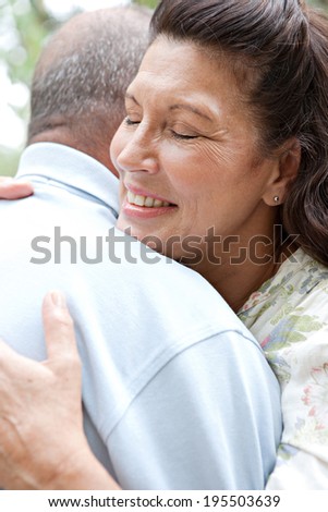 Close up portrait of a healthy senior couple relaxing on holiday in a luxury garden, hugging each other and being loving. Mature people enjoying romance and retirement, outdoors lifestyle.
