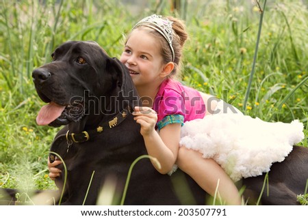 Close up portrait of a beautiful young girl wearing a fancy dress, sitting on her dog pet back, smiling and enjoying a summer holiday. Active family with pets outdoors lifestyle.