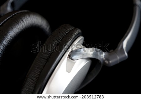 Macro close up still life detail view of a pair of high end professional quality headphones isolated against a black background. Interior stereo listening equipment device.