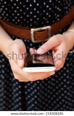 Professional business woman hands holding and using a modern intelligent digital smartphone with touch screen technology outdoors. Connectivity to internet on the go.