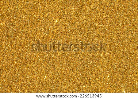 Abstract detail background of a vivid bright gold glitter shining and sparkling with texture. Galaxies and stars, full frame yellow noise color backdrop element.