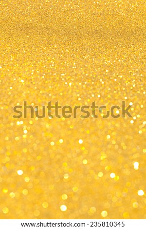 Abstract gold glitter festive background texture with shining glitter stars. Full frame yellow color christmas detail with blurred areas. Artistic colorful background drop frame space.