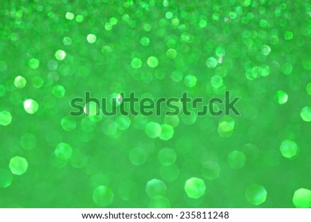 Abstract blurry green glitter festive background texture with shining glittering stars. Full frame green color christmas detail with blurred areas. Artistic colorful background drop frame space.