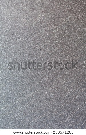 Over head detail close up view of a black gray slate stone with texture. Natural stone backdrop background in a neutral color. Full frame texture pattern background.