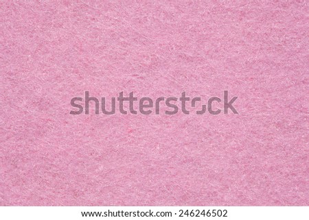 Close up detail view of a pink piece of textured felt fabric with rough touch. Full frame background texture pattern of art and stationery material in magenta color.