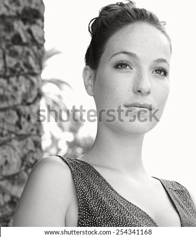 Black and white close up beauty portrait of young professional tourist woman visiting a picturesque street in a destination city, looking thoughtful relaxing on holiday. Travel and lifestyle outdoors.