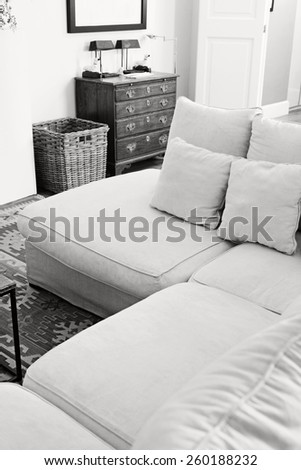 Black and white still life interior design home living room view with a white sofa with cushions, home interior detail. Aspirational and relaxing home family room, indoors living lifestyle.