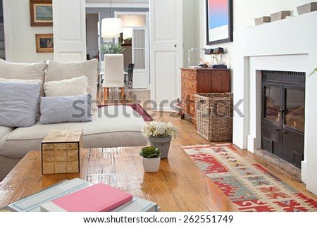 Still life of stylish, personal and elegant home living room with a large white sofa and a fireplace, decorated with quality carpets, house interior. Beautiful design home space family room, indoors.